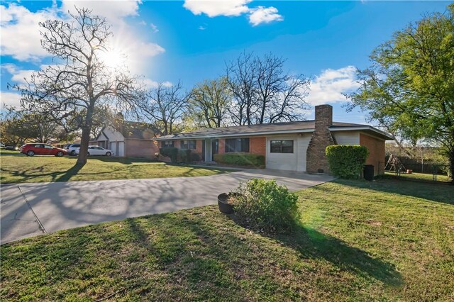 ranch-style house with driveway, a chimney, and a front yard