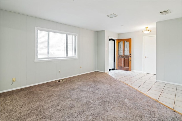 carpeted empty room with tile patterned floors and visible vents