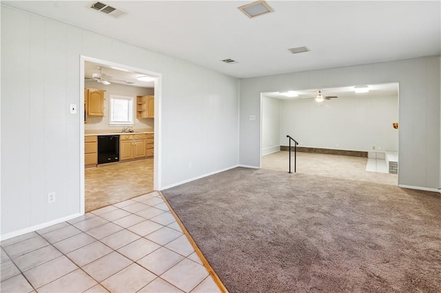 unfurnished living room featuring a sink, visible vents, a ceiling fan, and light colored carpet