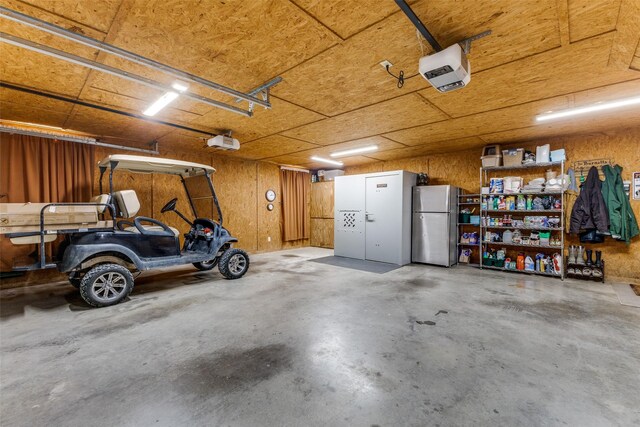garage with freestanding refrigerator and a garage door opener
