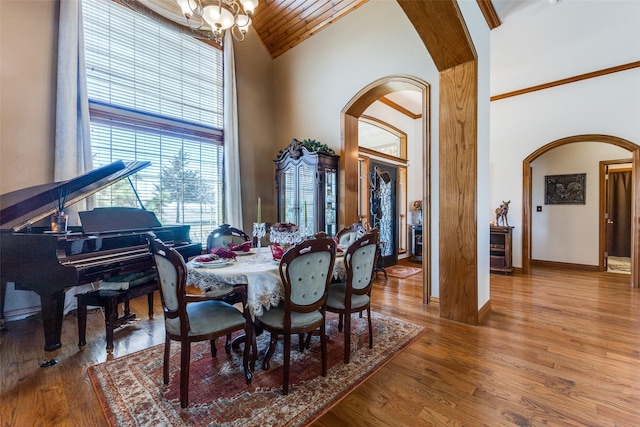 1752 County Road 1450, Bonham, TX 75418 - dining area with arched walkways, high vaulted ceiling, a chandelier, wood finished floors, and baseboards
