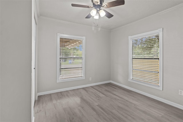 spare room featuring ornamental molding, ceiling fan, wood finished floors, and baseboards