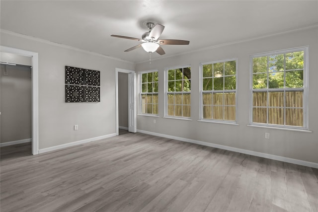 unfurnished bedroom with wood finished floors, baseboards, ornamental molding, and multiple windows