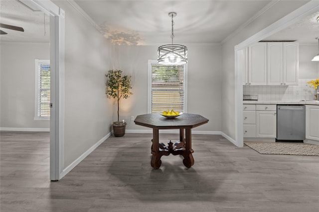 dining room featuring a healthy amount of sunlight, crown molding, and light wood-style flooring