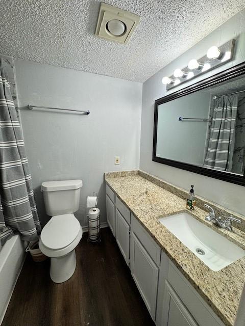2411 Northlake Ct, Irving, TX 75038 - full bathroom with wood finished floors, toilet, vanity, and a textured ceiling