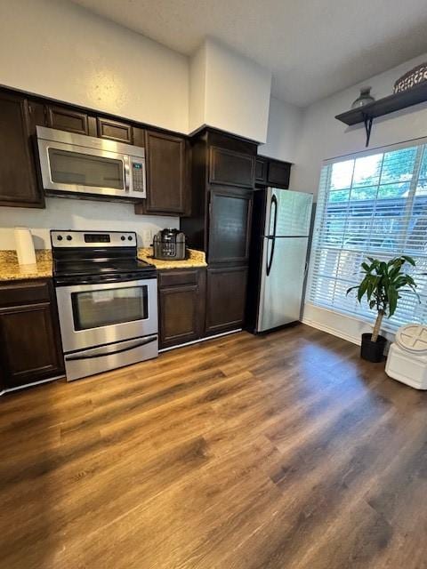 2411 Northlake Ct, Irving, TX 75038 - kitchen with stainless steel appliances, dark brown cabinets, light stone countertops, and wood finished floors