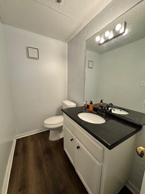 2411 Northlake Ct, Irving, TX 75038 - bathroom with wood finished floors, vanity, toilet, and a textured ceiling