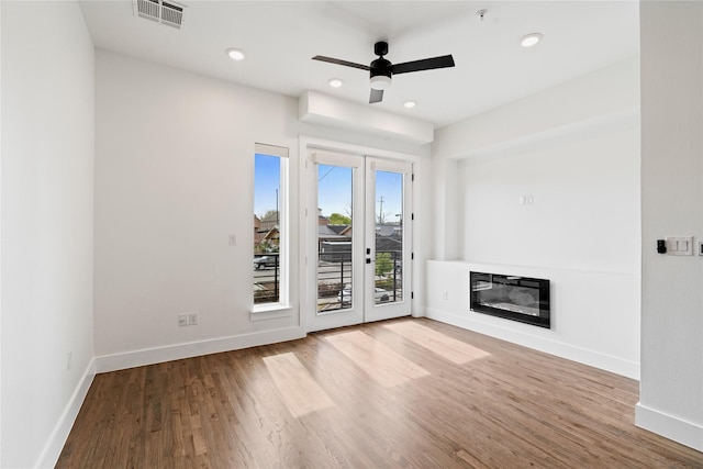 1804 Ripley St Unit 105, Dallas, TX 75204 - unfurnished living room featuring wood finished floors, baseboards, a glass covered fireplace, a ceiling fan, and recessed lighting