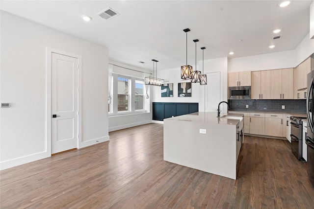 1804 Ripley St Unit 105, Dallas, TX 75204 - kitchen with light brown cabinets, stainless steel microwave, a chandelier, range with two ovens, and dark wood finished floors