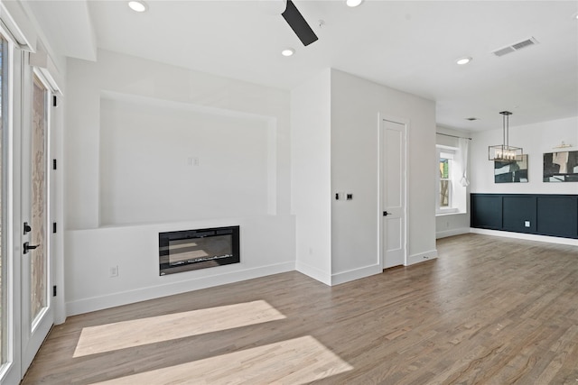 1804 Ripley St Unit 105, Dallas, TX 75204 - unfurnished living room featuring wood finished floors, a glass covered fireplace, baseboards, recessed lighting, and ceiling fan