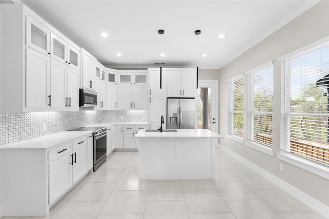 2111 Brookhaven Dr, Dallas, TX 75224 - kitchen with light countertops, a kitchen island with sink, stainless steel appliances, a sink, and backsplash