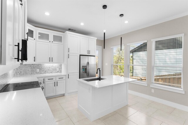 2111 Brookhaven Dr, Dallas, TX 75224 - kitchen featuring an island with sink, a sink, stainless steel fridge with ice dispenser, pendant lighting, and backsplash