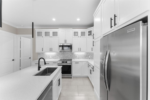 2111 Brookhaven Dr, Dallas, TX 75224 - kitchen featuring stainless steel appliances, tasteful backsplash, glass insert cabinets, a sink, and light tile patterned floors