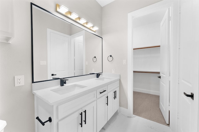 2111 Brookhaven Dr, Dallas, TX 75224 - bathroom with double vanity, a sink, a walk in closet, and baseboards