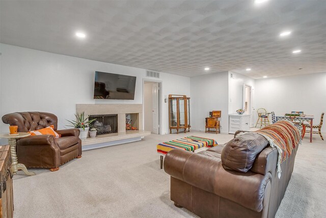 living room with a high end fireplace, visible vents, recessed lighting, and carpet flooring
