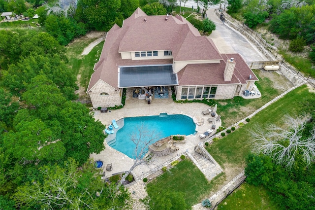 back of property with a patio area, stone siding, an outdoor pool, and a fenced backyard
