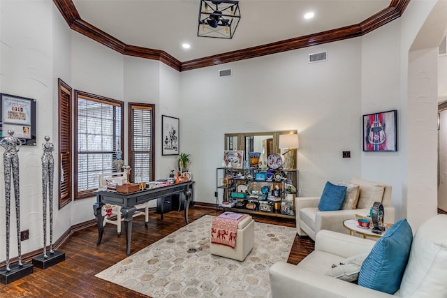 living room with crown molding, wood finished floors, baseboards, recessed lighting, and a towering ceiling