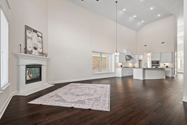 15664 Wild Cherry Ln, Fort Worth, TX 76262 - unfurnished living room featuring high vaulted ceiling, a glass covered fireplace, dark wood-style floors, and plenty of natural light
