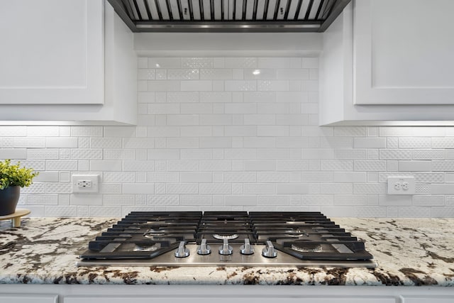 15664 Wild Cherry Ln, Fort Worth, TX 76262 - kitchen view of stainless steel gas cooktop, white cabinetry, premium range hood, and tasteful backsplash