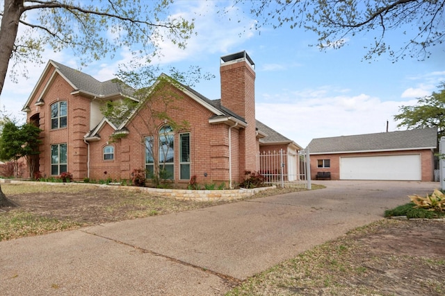 view of front of house with brick siding, driveway, a chimney, and a garage
