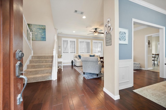 entrance foyer with dark wood-style floors, visible vents, crown molding, stairs, and ceiling fan