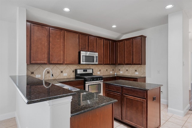 808 Goldenmist Dr, Little Elm, TX 75068 - kitchen with stainless steel appliances, dark stone countertops, a peninsula, baseboards, and recessed lighting