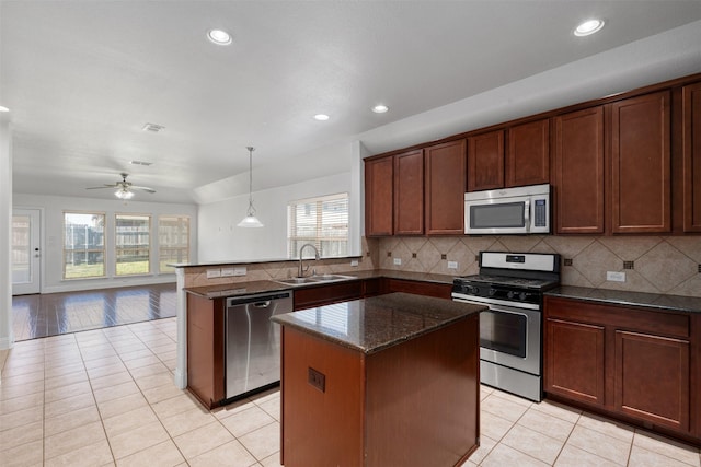 808 Goldenmist Dr, Little Elm, TX 75068 - kitchen with stainless steel appliances, a sink, light tile patterned floors, a peninsula, and recessed lighting