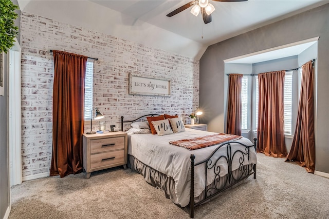 bedroom with light colored carpet, vaulted ceiling, brick wall, and a ceiling fan