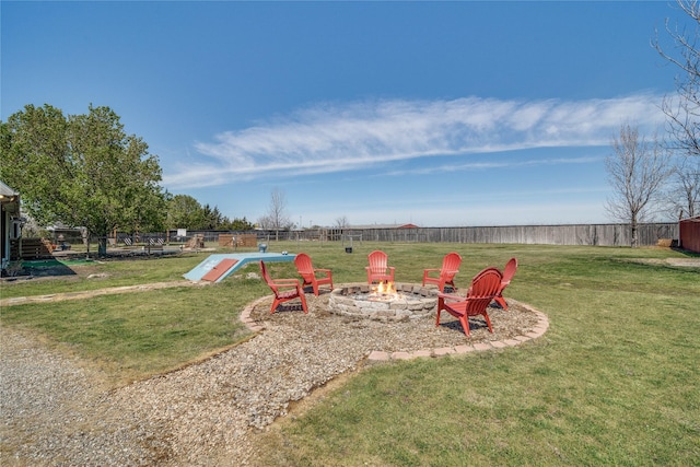 view of yard with fence and an outdoor fire pit
