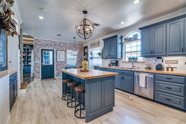 kitchen featuring blue cabinets, wooden counters, a sink, dishwasher, and a notable chandelier