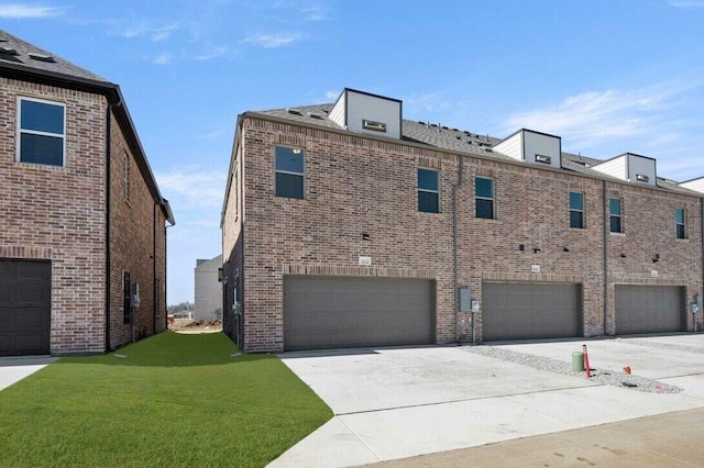 2412 Bulin Dr, Mansfield, TX 76063 - view of home's exterior featuring an attached garage, a yard, brick siding, and concrete driveway