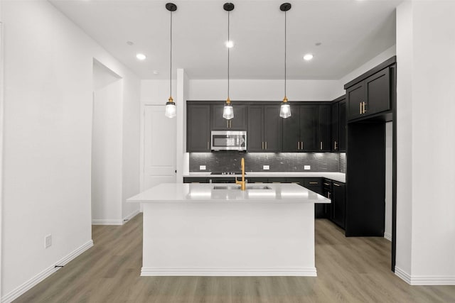 2412 Bulin Dr, Mansfield, TX 76063 - kitchen featuring stainless steel microwave, light wood-type flooring, decorative backsplash, light countertops, and recessed lighting