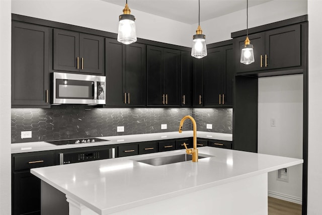 2412 Bulin Dr, Mansfield, TX 76063 - kitchen with stainless steel microwave, a sink, black electric cooktop, tasteful backsplash, and dark cabinets