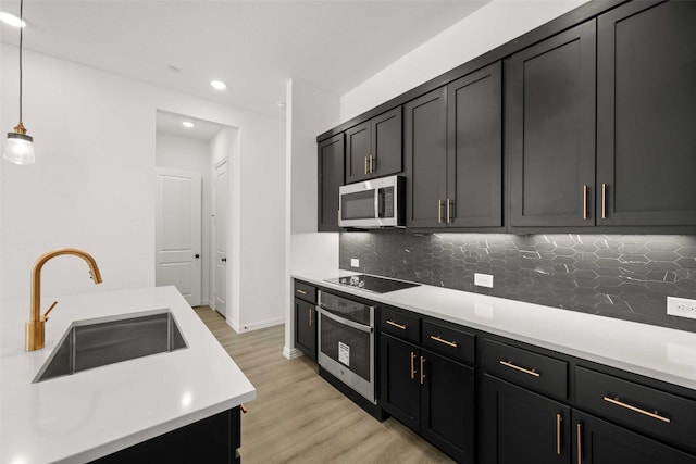 2412 Bulin Dr, Mansfield, TX 76063 - kitchen with stainless steel appliances, a sink, light countertops, light wood-style floors, and backsplash