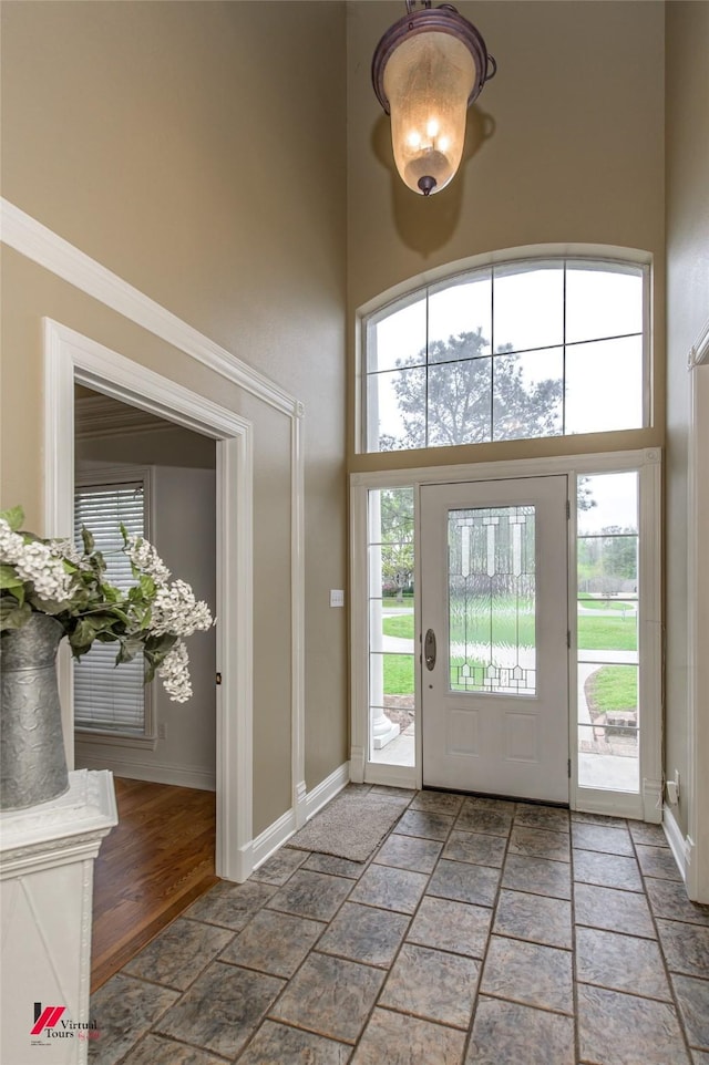 339 Hunters Holw, Bossier City, LA 71111 - foyer featuring baseboards, a towering ceiling, stone tile flooring, and a healthy amount of sunlight