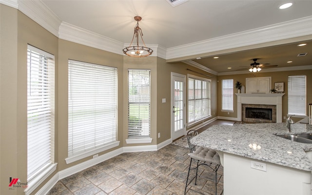 339 Hunters Holw, Bossier City, LA 71111 - kitchen featuring crown molding, stone finish flooring, baseboards, a fireplace, and a sink