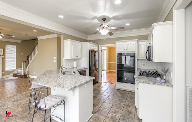 339 Hunters Holw, Bossier City, LA 71111 - kitchen with a breakfast bar, a sink, a ceiling fan, a peninsula, and black appliances