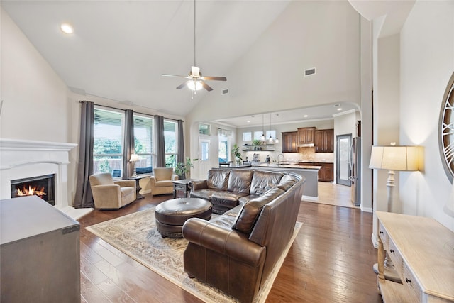 216 Equestrian Rd, Hickory Creek, TX 75065 - living room featuring ceiling fan, a lit fireplace, dark wood-type flooring, high vaulted ceiling, and recessed lighting