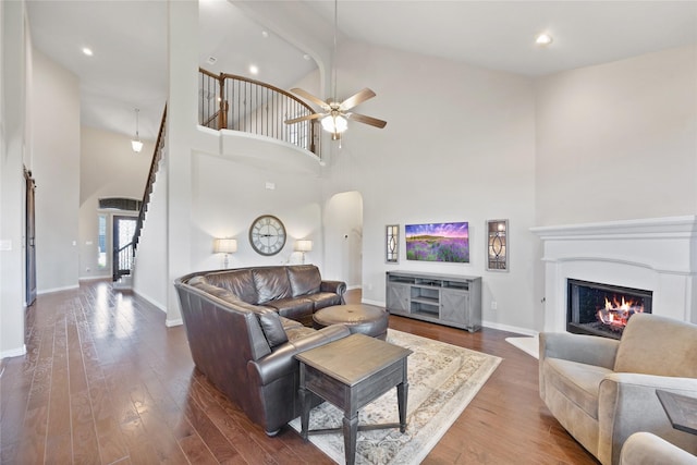 216 Equestrian Rd, Hickory Creek, TX 75065 - living area featuring arched walkways, high vaulted ceiling, stairway, baseboards, and wood finished floors
