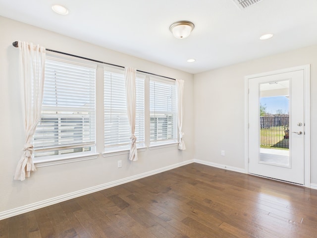 unfurnished room with dark wood finished floors, baseboards, and plenty of natural light