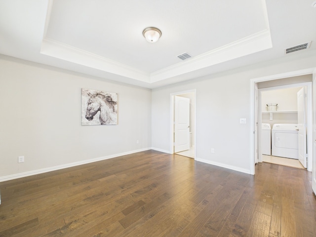 unfurnished room featuring crown molding, washing machine and dryer, visible vents, and a tray ceiling