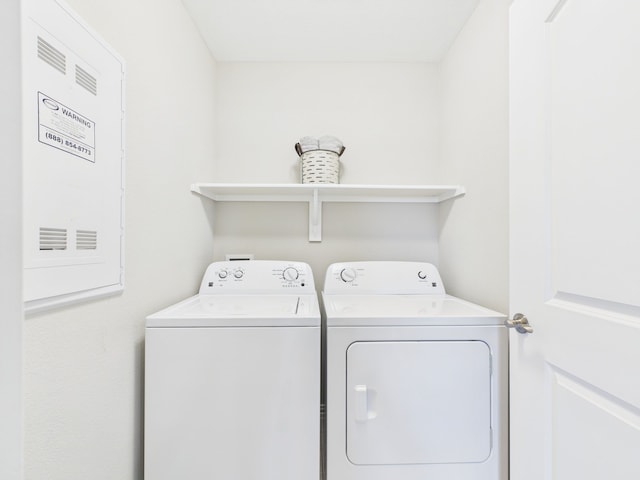clothes washing area featuring laundry area and washer and clothes dryer