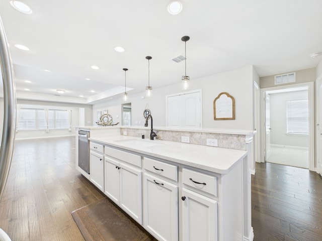 kitchen featuring dark wood-type flooring, visible vents, white cabinetry, and a sink