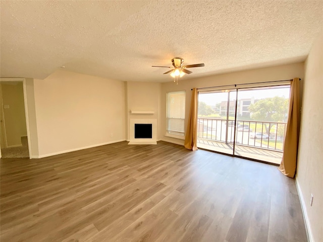11490 Audelia Rd Unit 326, Dallas, TX 75243 - unfurnished living room with baseboards, a ceiling fan, a textured ceiling, and wood finished floors