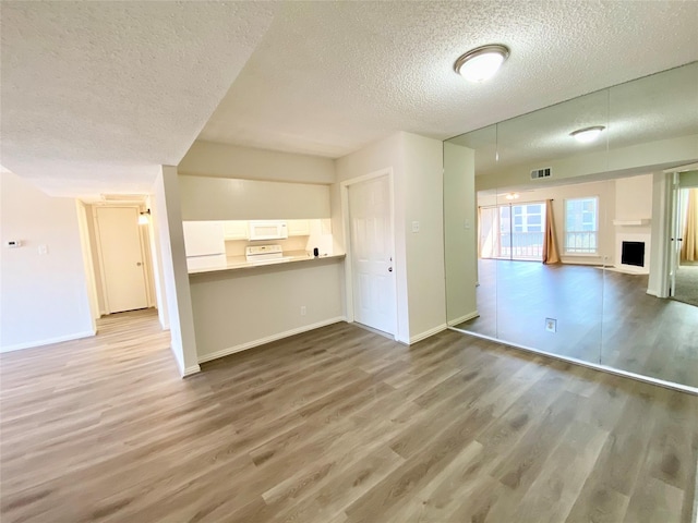 11490 Audelia Rd Unit 326, Dallas, TX 75243 - unfurnished living room with baseboards, a textured ceiling, visible vents, and wood finished floors