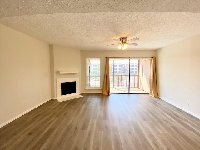 11490 Audelia Rd Unit 326, Dallas, TX 75243 - unfurnished living room with baseboards, a fireplace with flush hearth, ceiling fan, and wood finished floors