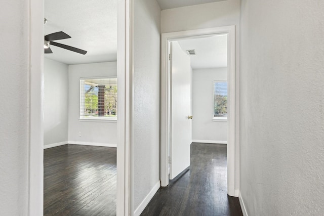 10319 Sylvia Dr, Dallas, TX 75228 - corridor featuring dark wood-type flooring, a textured wall, and baseboards