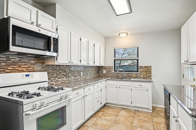10319 Sylvia Dr, Dallas, TX 75228 - kitchen featuring white gas stove, stainless steel microwave, a sink, decorative backsplash, and white cabinets