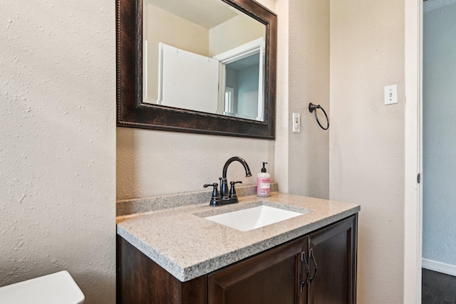 10319 Sylvia Dr, Dallas, TX 75228 - bathroom with vanity, a textured wall, and toilet
