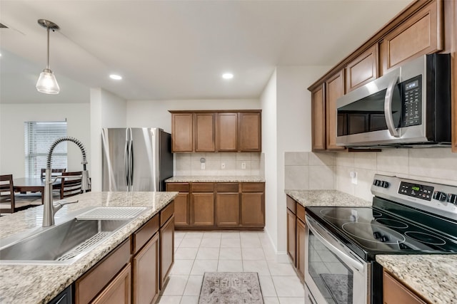 2282 Torch Lake Dr, Forney, TX 75126 - kitchen with a sink, stainless steel appliances, brown cabinetry, and pendant lighting